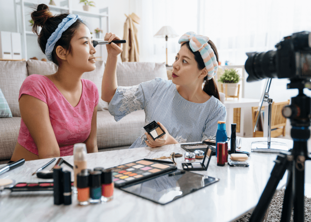 Two women are recording themselves doing a makeover with their new makeup products.